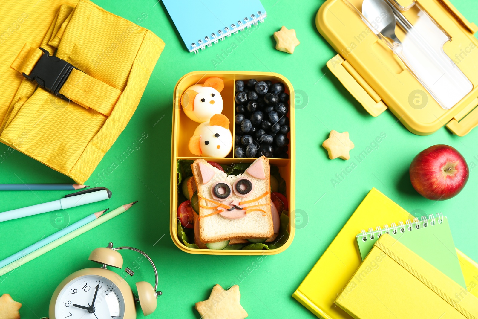 Photo of Flat lay composition with lunch box and snacks on green table