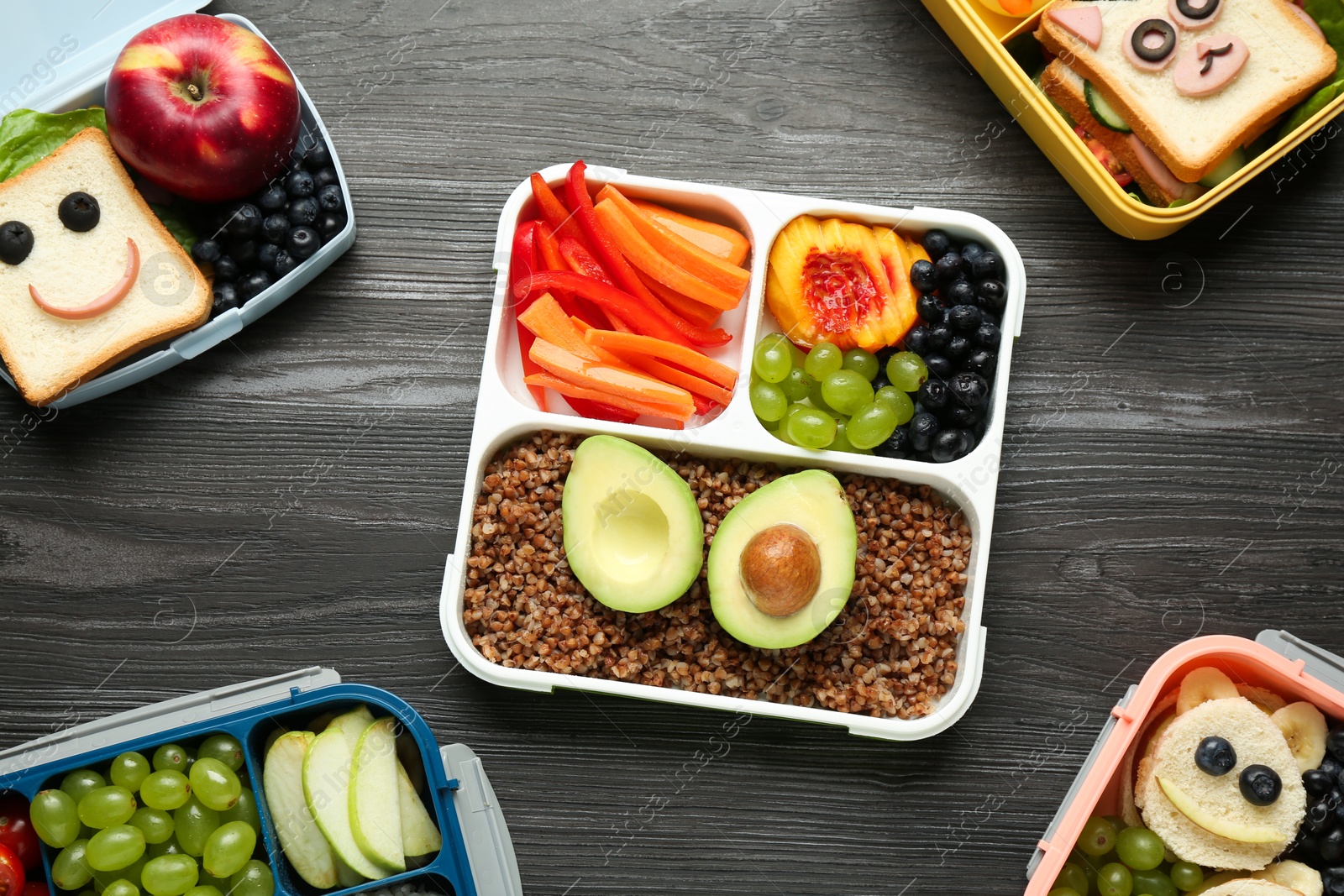 Photo of Lunch boxes with different snacks on wooden table, flat lay