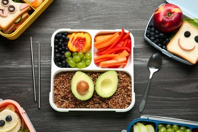 Photo of Lunch boxes with different snacks and cutlery on wooden table, flat lay