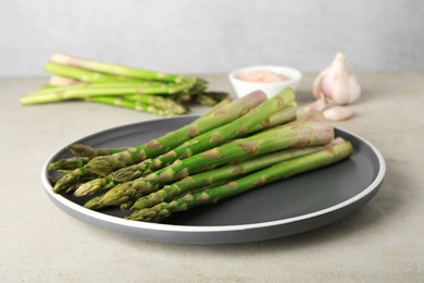 Fresh green asparagus stems on gray table, closeup