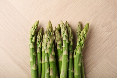 Fresh green asparagus stems on wooden table, top view