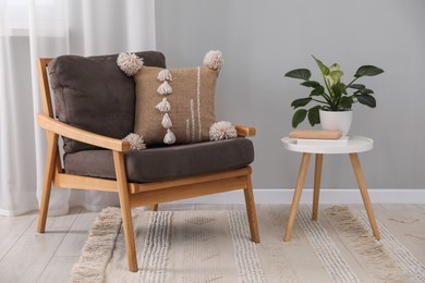 Photo of Soft pillow on armchair near coffee table indoors