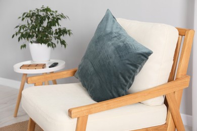 Photo of Soft pillow on armchair near coffee table indoors