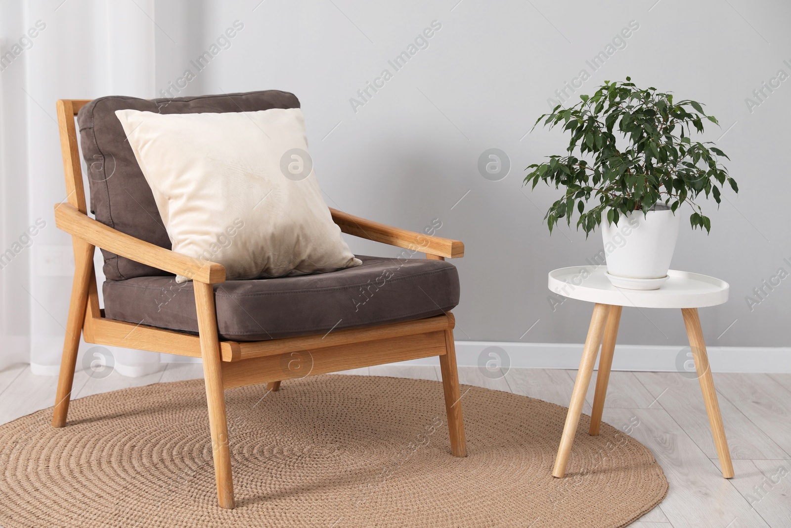 Photo of Soft pillow on armchair near coffee table indoors