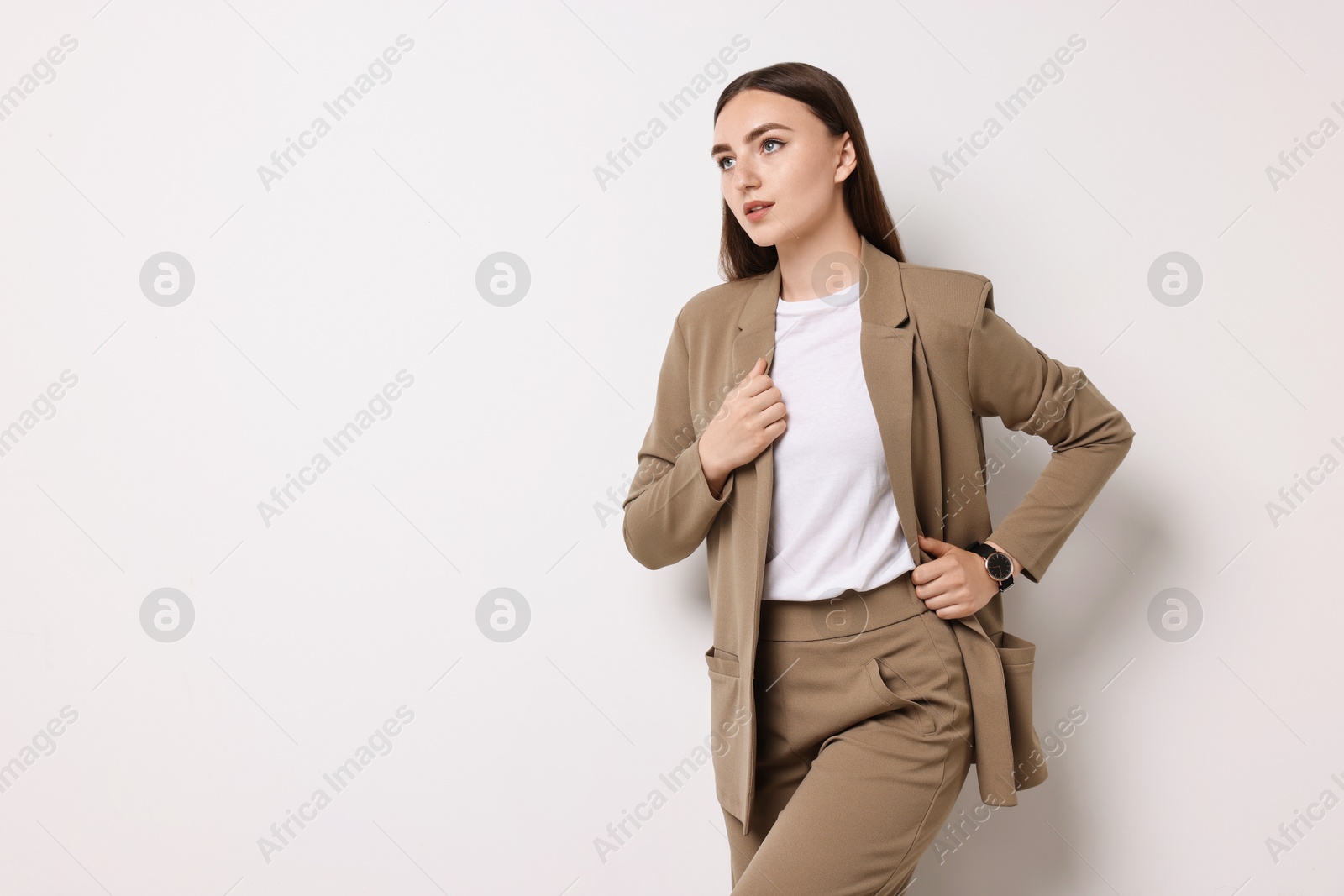 Photo of Beautiful woman in beige suit on white background, space for text