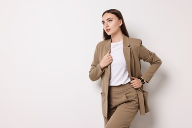 Photo of Beautiful woman in beige suit on white background, space for text