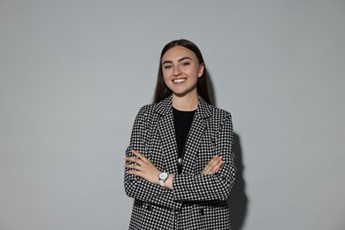 Photo of Beautiful woman in stylish suit on gray background