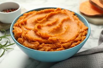 Tasty mashed sweet potato in bowl on table, closeup