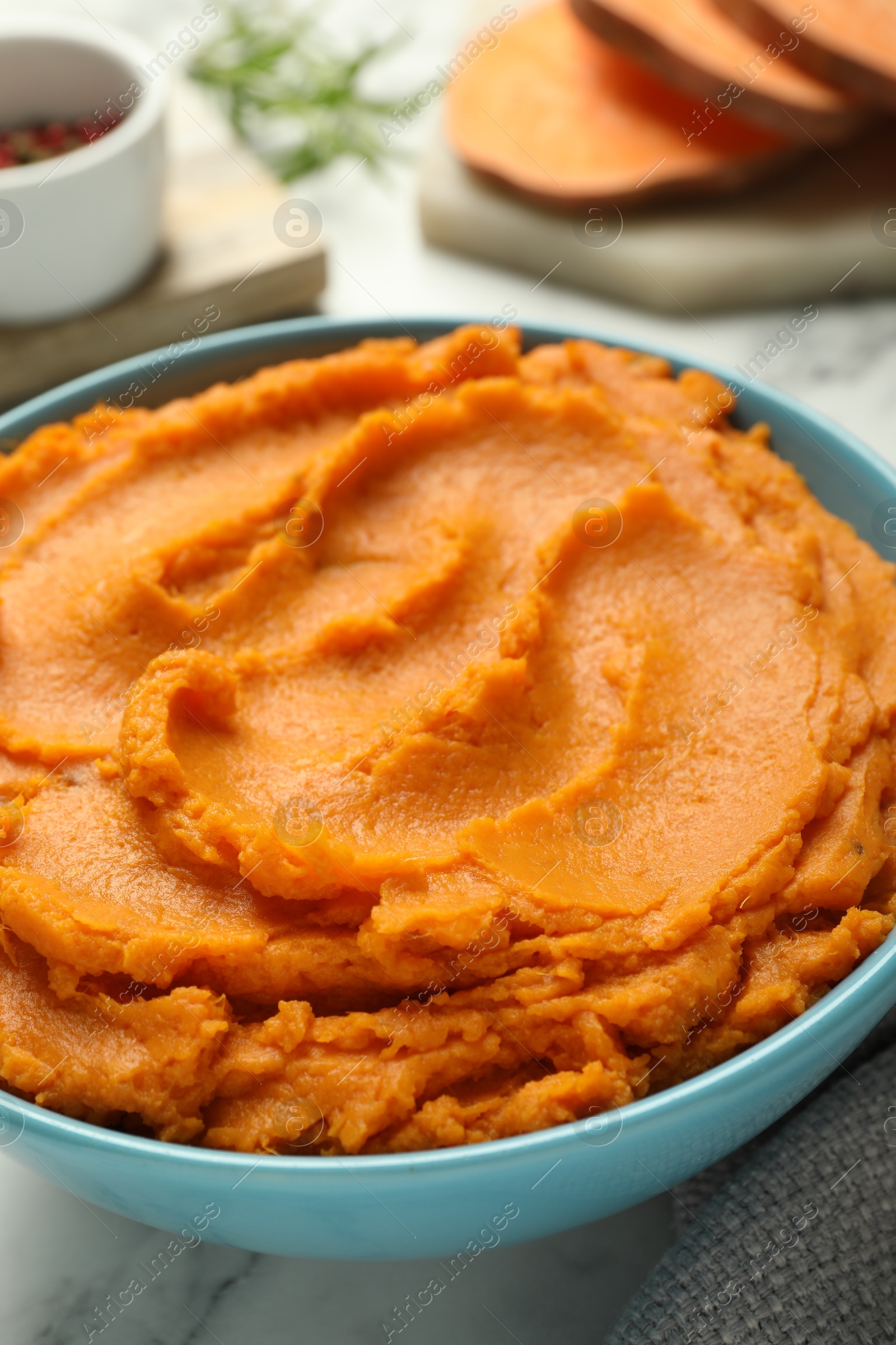 Photo of Tasty mashed sweet potato in bowl on table, closeup