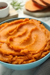 Tasty mashed sweet potato in bowl on table, closeup