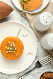 Photo of Tasty mashed sweet potato, rosemary and walnuts served on white marble table, flat lay