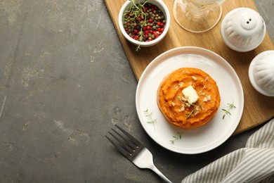 Photo of Tasty mashed sweet potato, butter, thyme and walnuts served on grey textured table, flat lay. Space for text