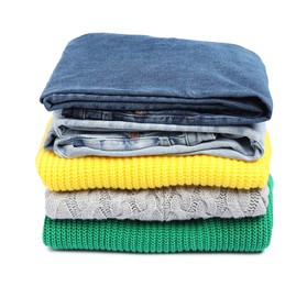 Stack of sweaters and jeans isolated on white