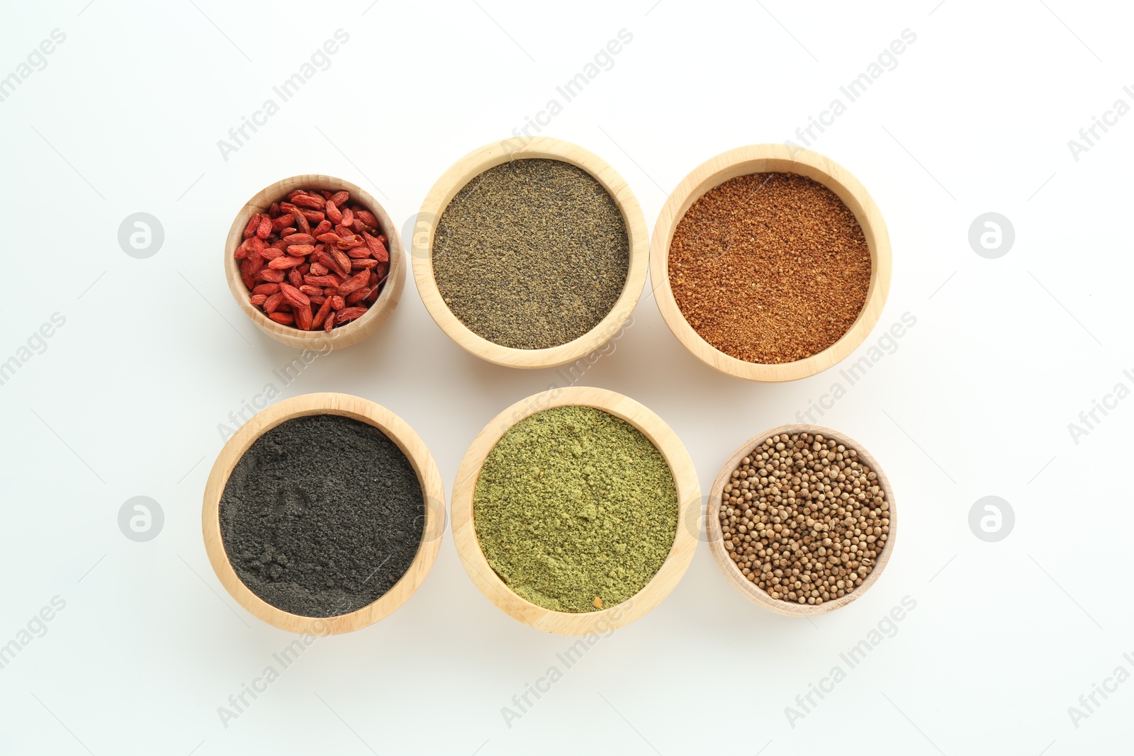 Photo of Different superfood powders and goji berries in bowls on white background, flat lay