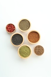 Photo of Different superfood powders and goji berries in bowls on white background, flat lay