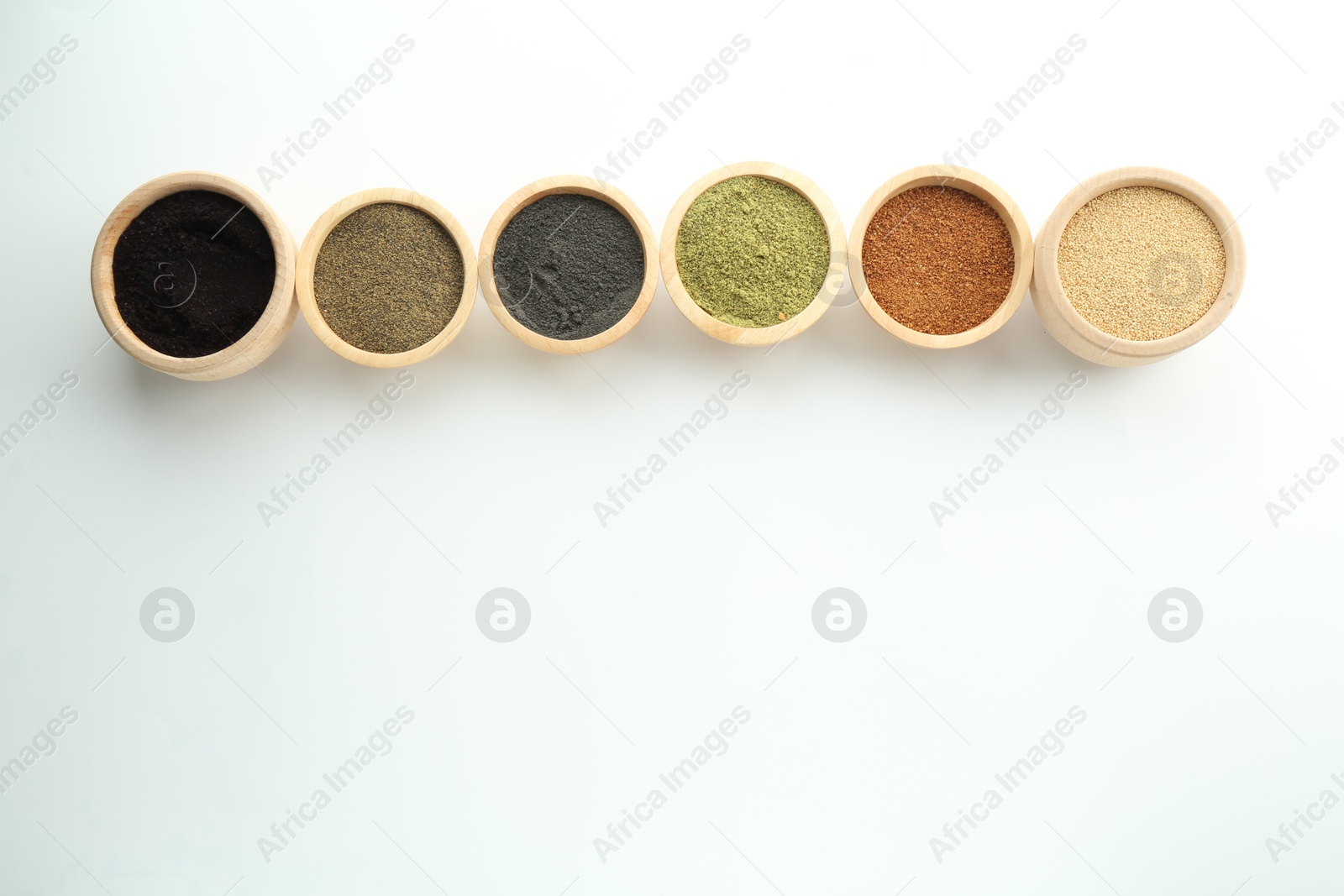 Photo of Different superfood powders in bowls on white background, flat lay. Space for text