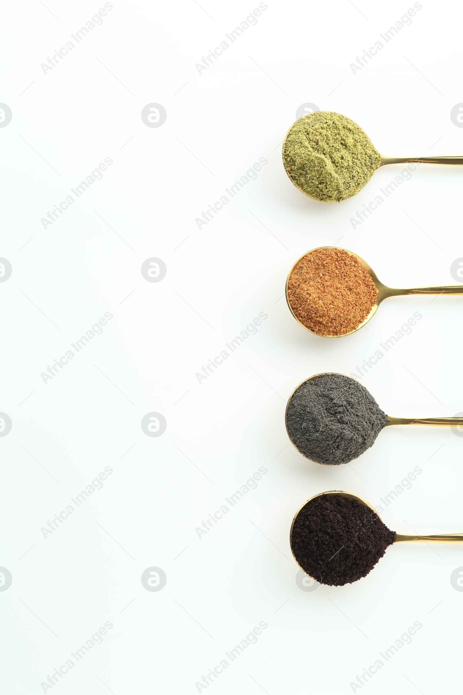 Photo of Spoons with different superfood powders on white background, flat lay. Space for text