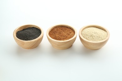 Different superfood powders in bowls on white background