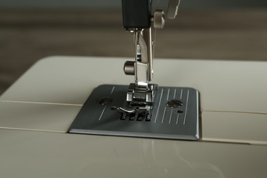 Photo of Modern sewing machine on light background, closeup