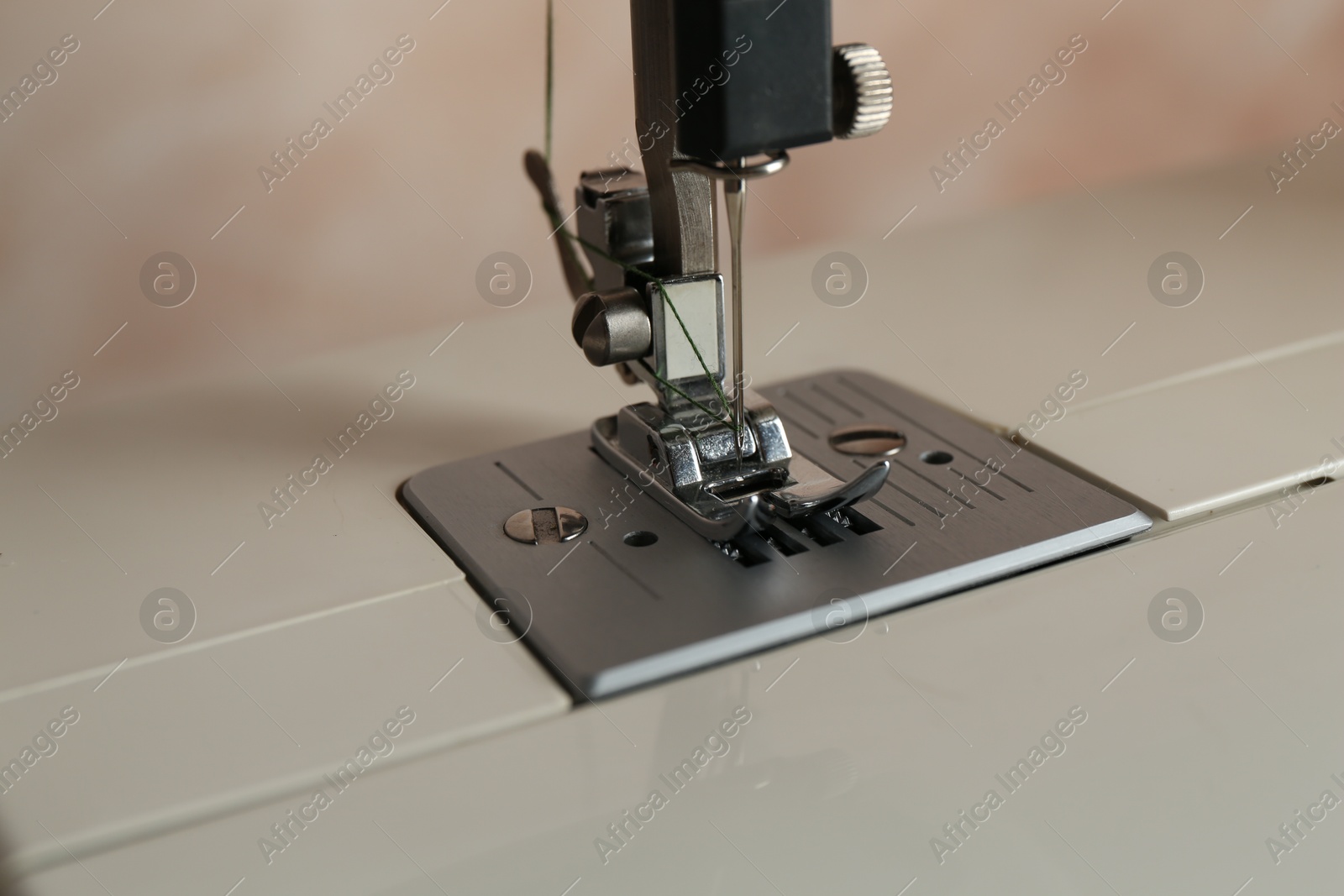 Photo of Modern sewing machine on light background, closeup