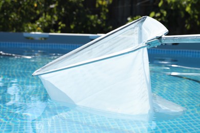 Photo of Cleaning swimming pool with skimmer net, closeup