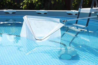 Photo of Cleaning swimming pool with skimmer net, closeup