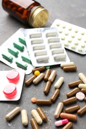 Photo of Pharmacist. Different pills and plastic bottle on grey table, closeup