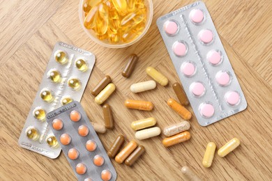 Photo of Pharmacist. Different pills on wooden table, flat lay