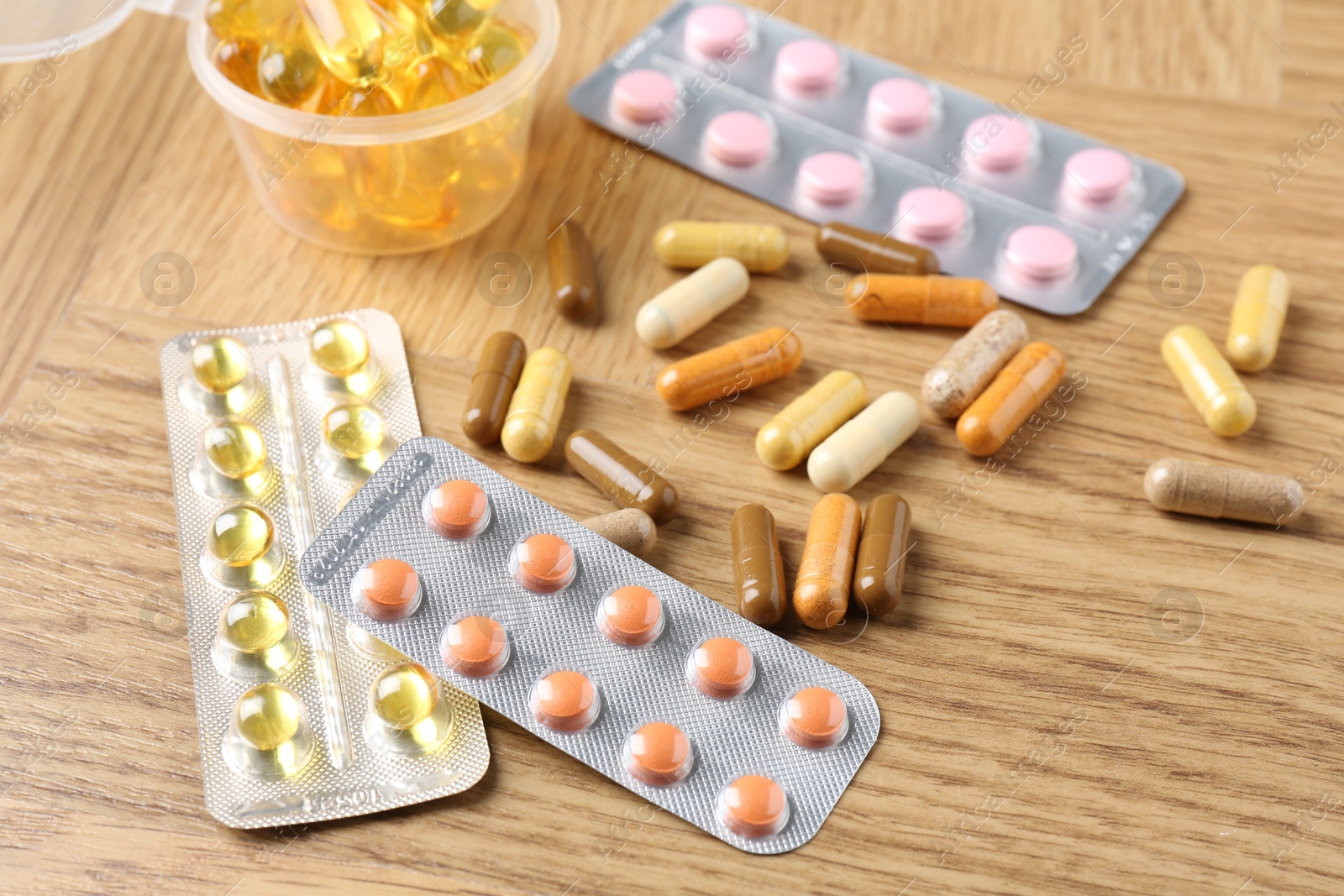 Photo of Pharmacist. Different pills on wooden table, closeup