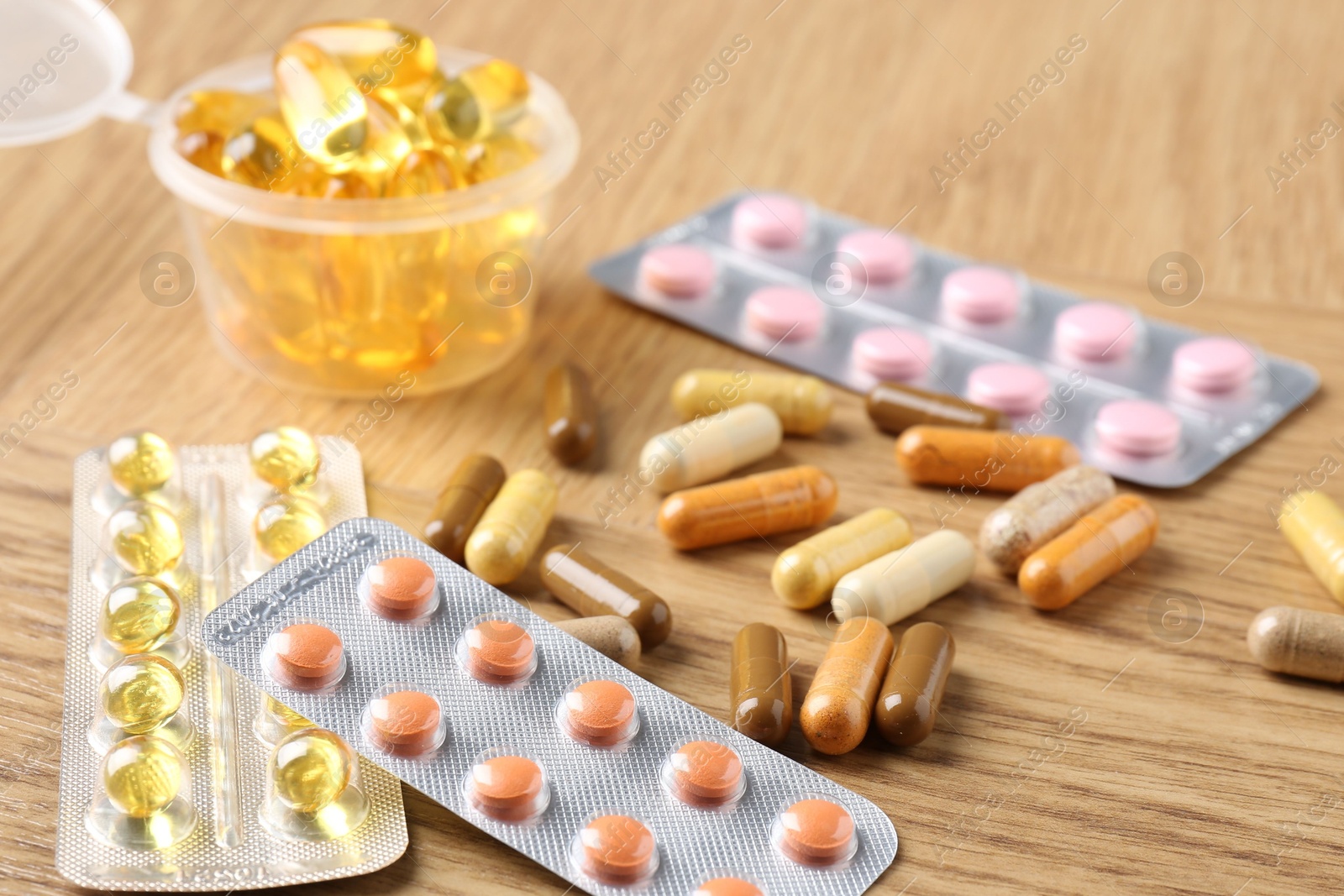 Photo of Pharmacist. Different pills on wooden table, closeup