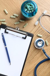 Photo of Pharmacist. Many pills, stethoscope, clipboard and pen on wooden table, flat lay