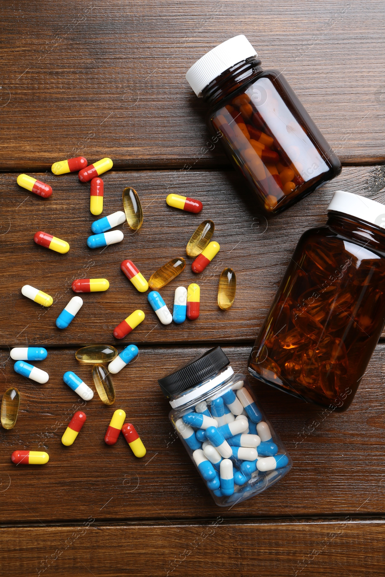 Photo of Pharmacist. Different pills and plastic bottles on wooden table, flat lay