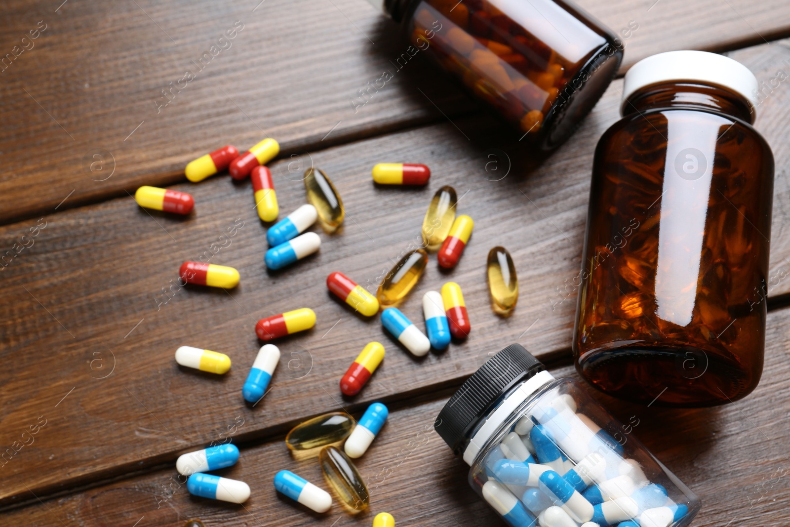 Photo of Pharmacist. Different pills and plastic bottles on wooden table