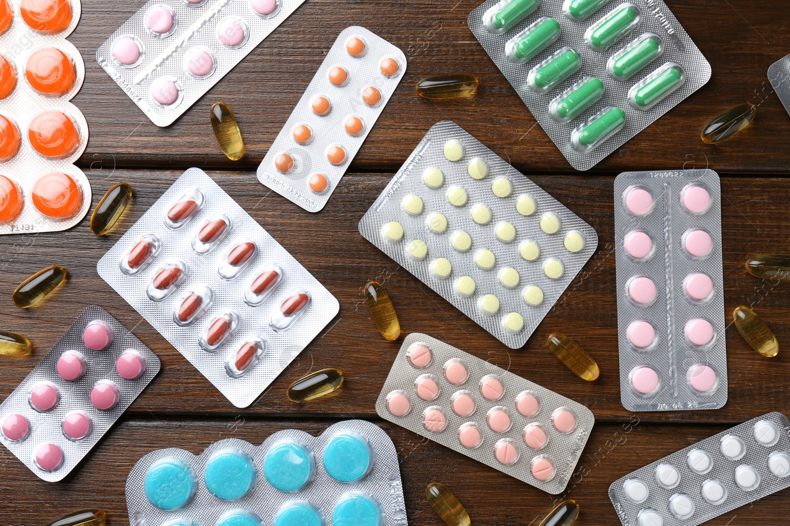 Photo of Pharmacist. Different pills on wooden table, flat lay