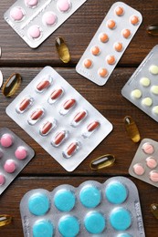 Photo of Pharmacist. Different pills on wooden table, flat lay