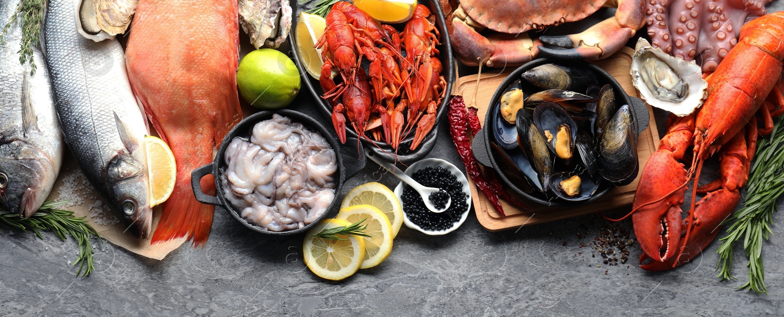 Image of Many different fresh sea food on grey table, flat lay. Banner design