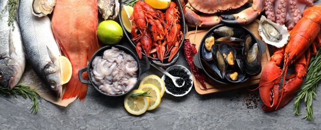 Image of Many different fresh sea food on grey table, flat lay. Banner design