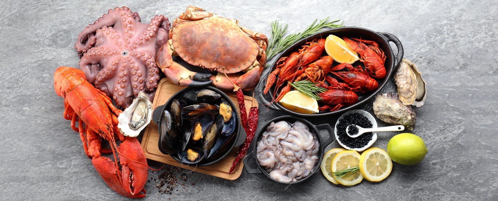 Image of Many different fresh sea food on grey table, flat lay. Banner design