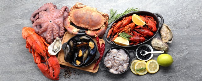 Image of Many different fresh sea food on grey table, flat lay. Banner design