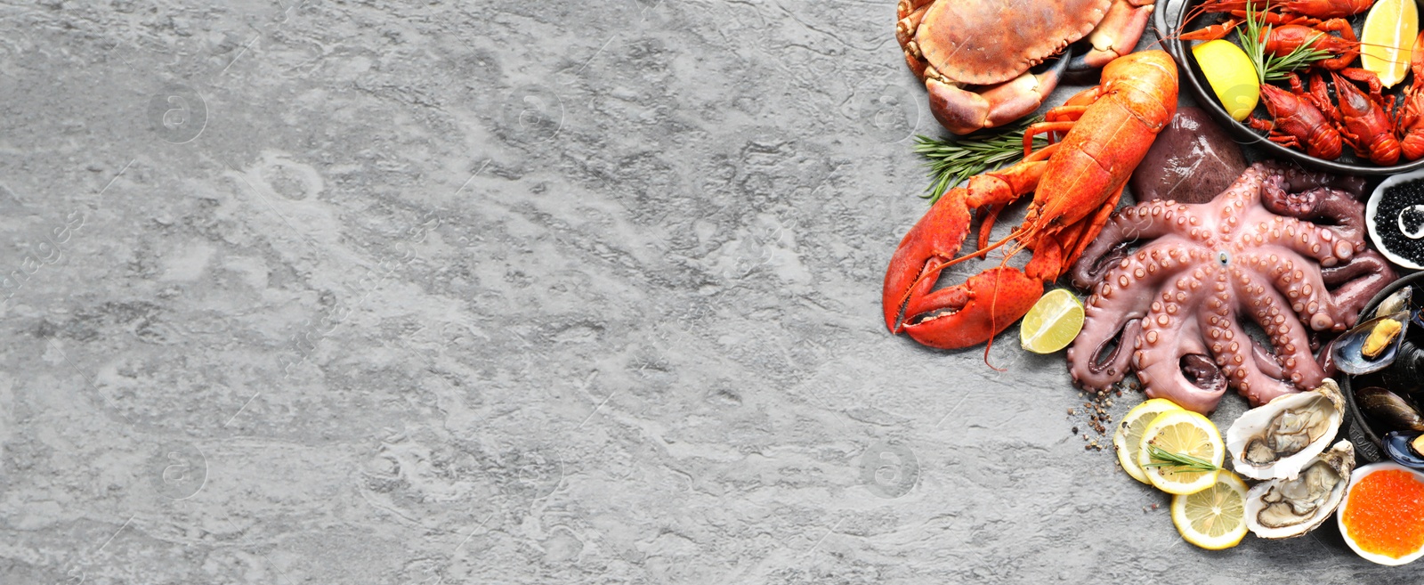 Image of Many different fresh sea food on grey table, flat lay. Banner design with space for text