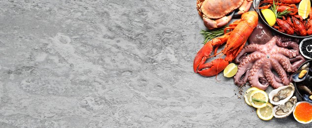 Image of Many different fresh sea food on grey table, flat lay. Banner design with space for text