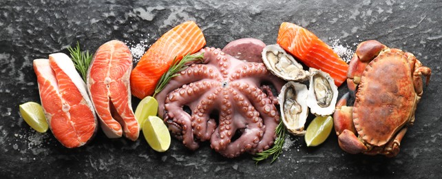 Image of Many different fresh sea food on dark table, flat lay. Banner design