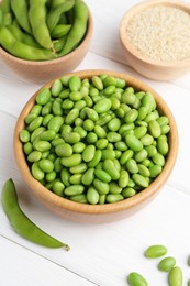 Fresh edamame soybeans, pods and seeds on white wooden table, above view