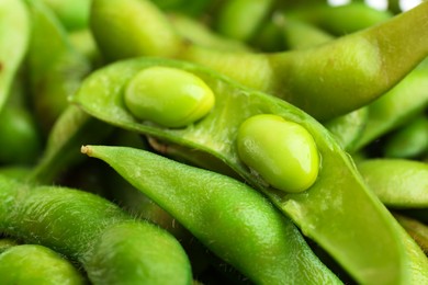 Fresh edamame pods with soybeans as background, closeup