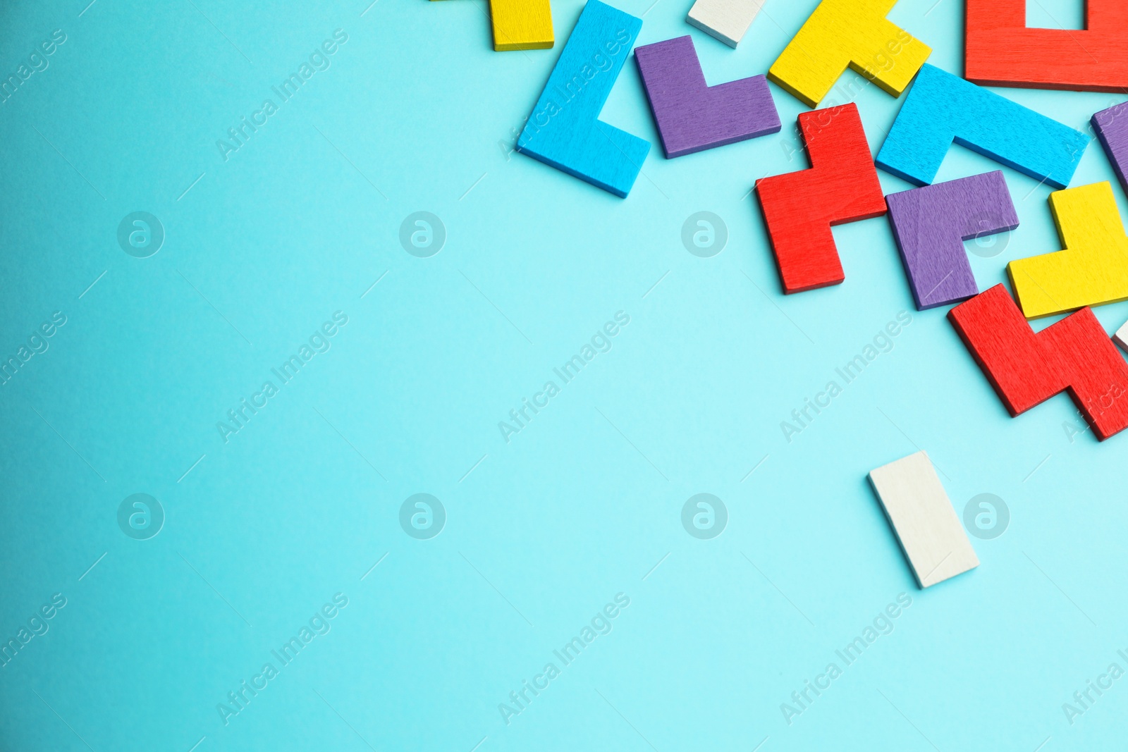 Photo of Colorful wooden puzzle pieces on light blue background, top view. Space for text