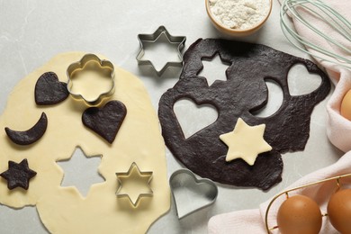 Photo of Raw doughs and cookie cutters on light table, flat lay