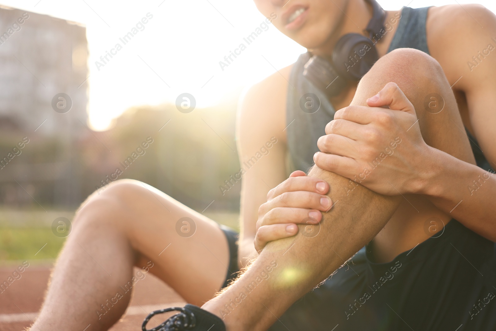 Photo of Sportsman with leg injury at stadium, closeup