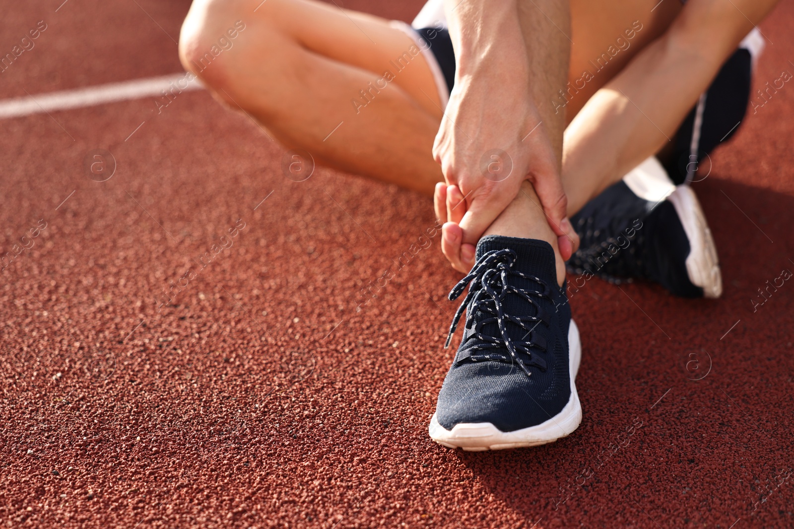 Photo of Sportsman with injured leg at stadium, closeup. Space for text