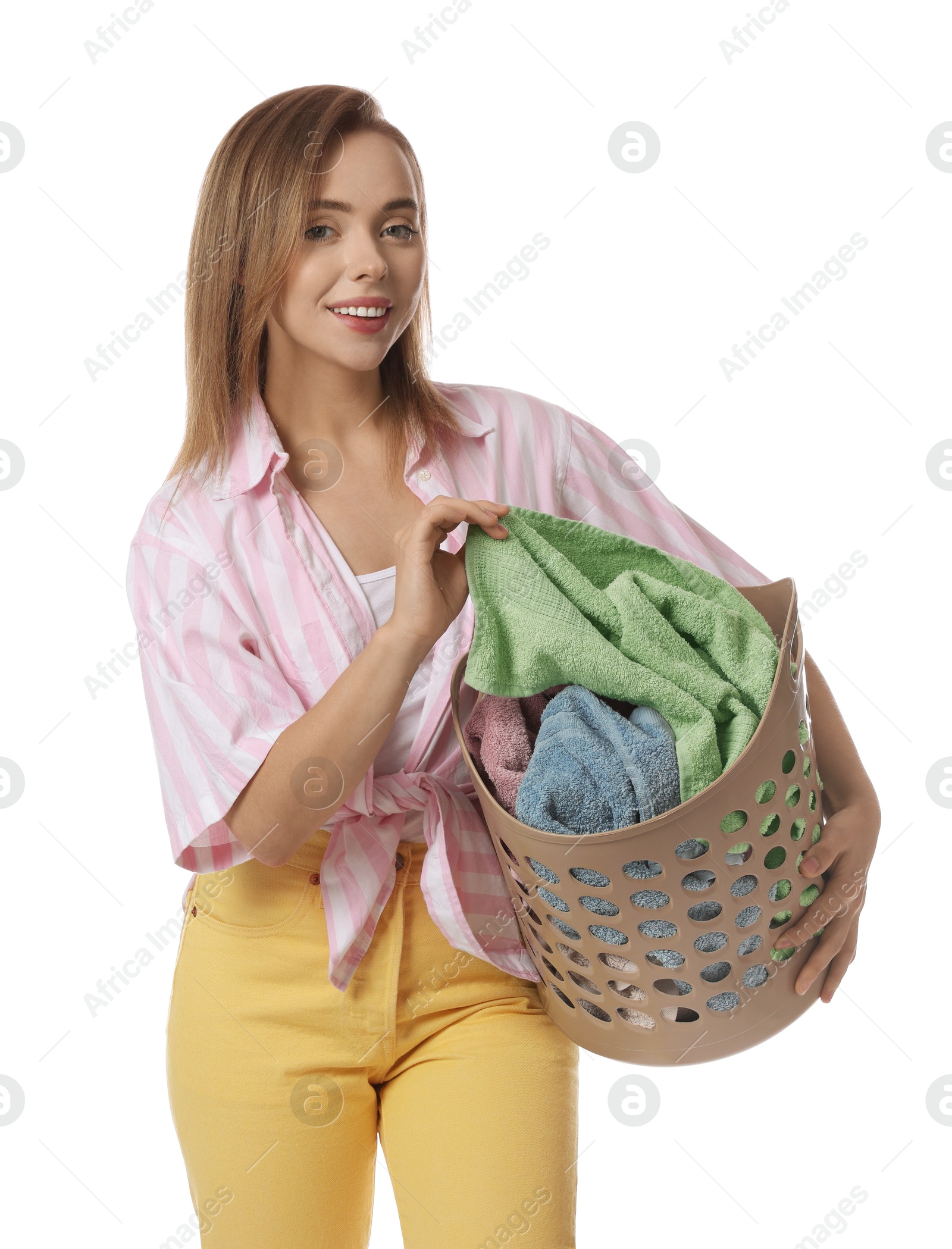 Photo of Happy young housewife with basket full of laundry on white background