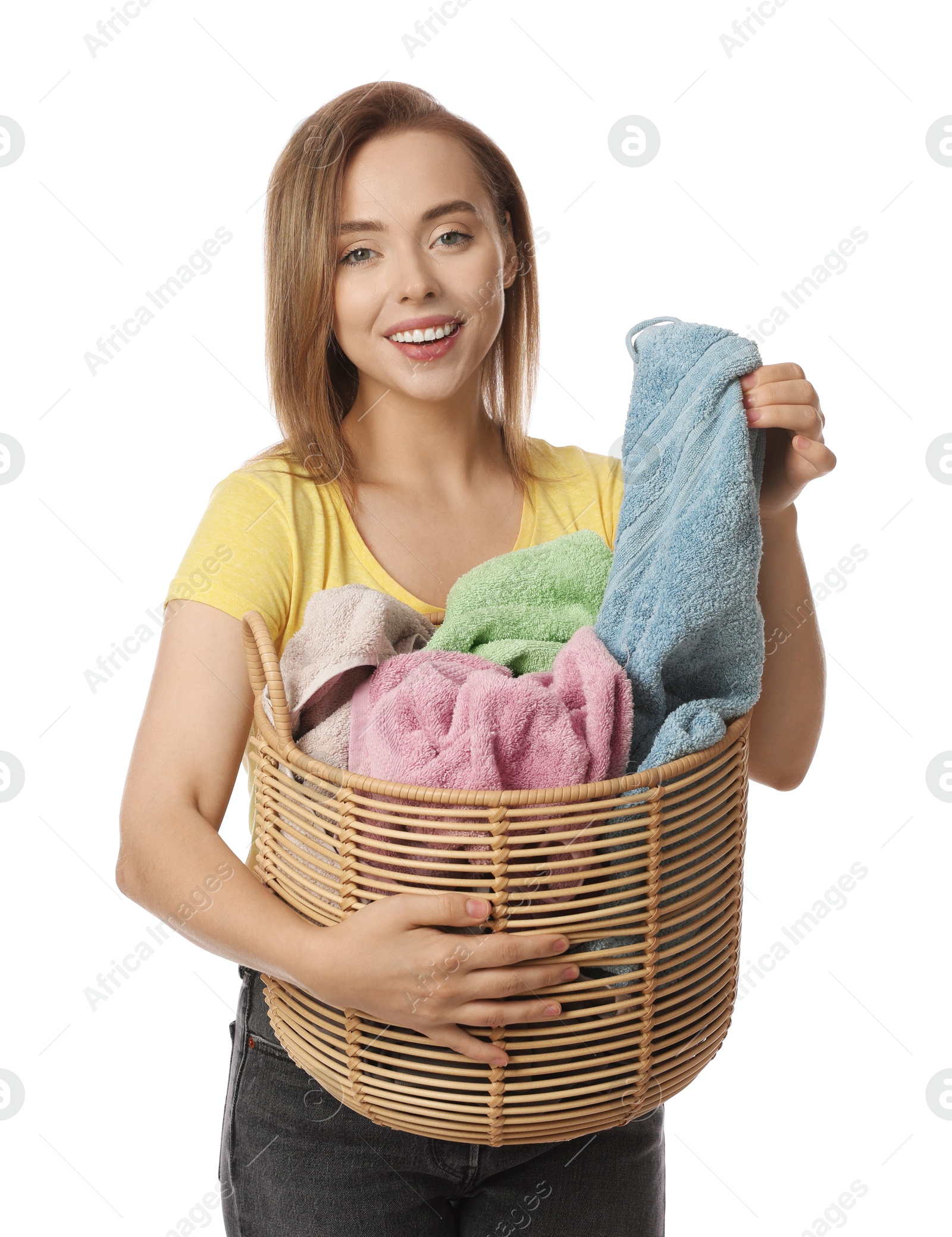 Photo of Happy young housewife with basket full of laundry on white background